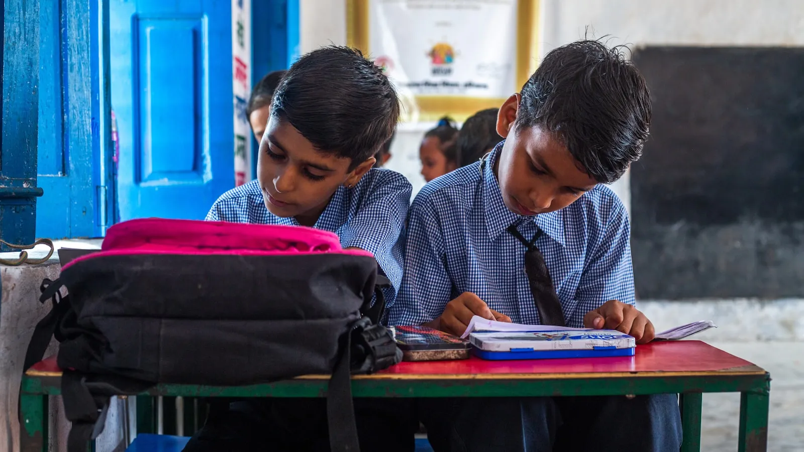 Two students concentrating on books at a shared desk